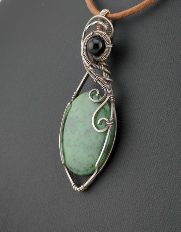 Maw Sit Sit Pendant, set in Sterling Silver, accented with black Agate.