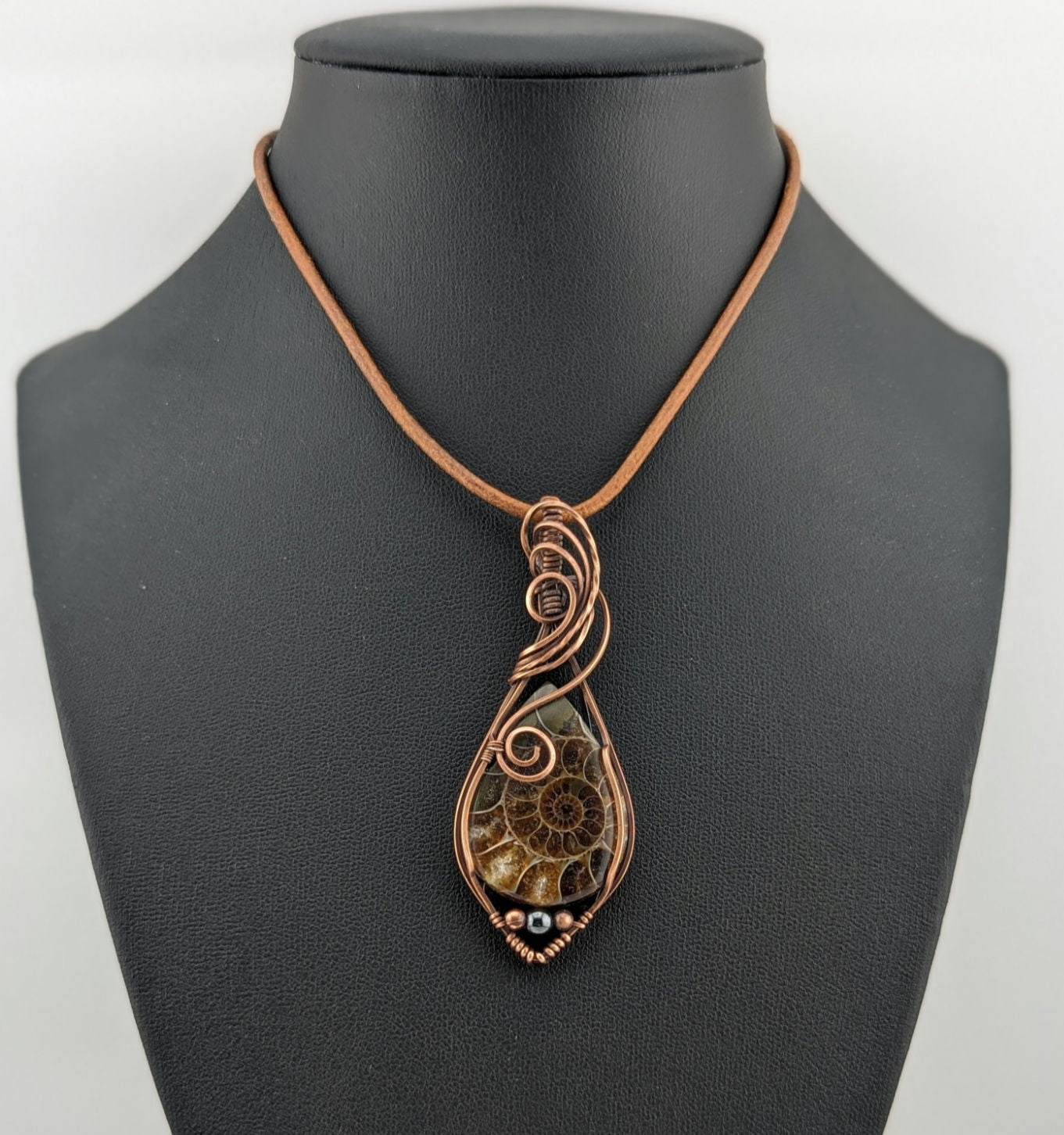 Ammonite pendant, set in antiqued copper, accented with Hematite