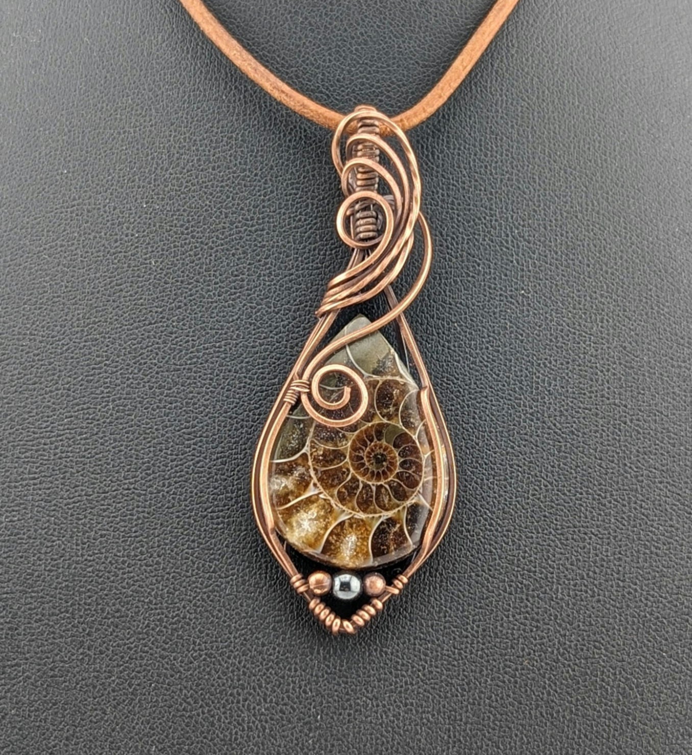 Ammonite pendant, set in antiqued copper, accented with Hematite