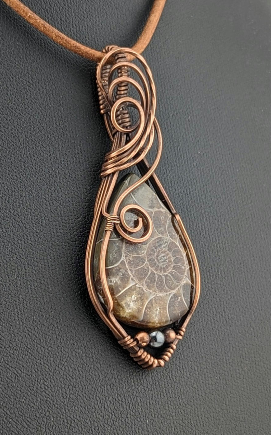 Ammonite pendant, set in antiqued copper, accented with Hematite