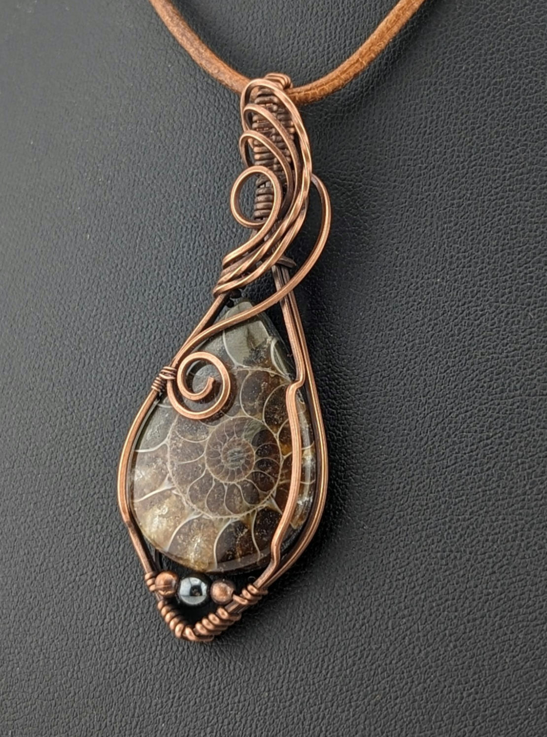 Ammonite pendant, set in antiqued copper, accented with Hematite