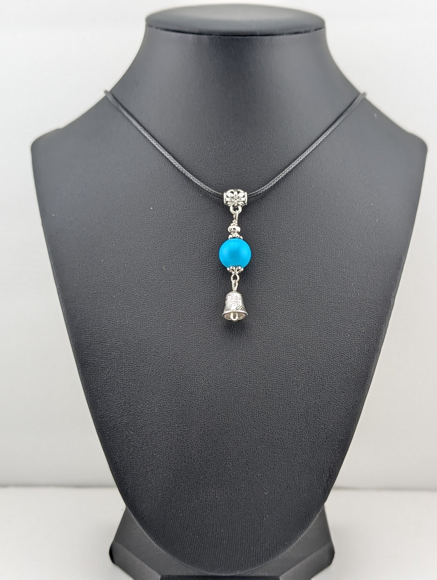 Turquoise pendant with a Bell charm, in antiqued Silver finish