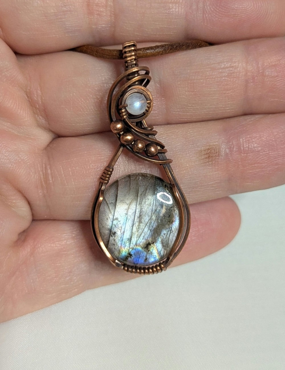 Labradorite gemstone pendant with Blue and Silver flash, accented with Moonstone and set in antiqued copper.