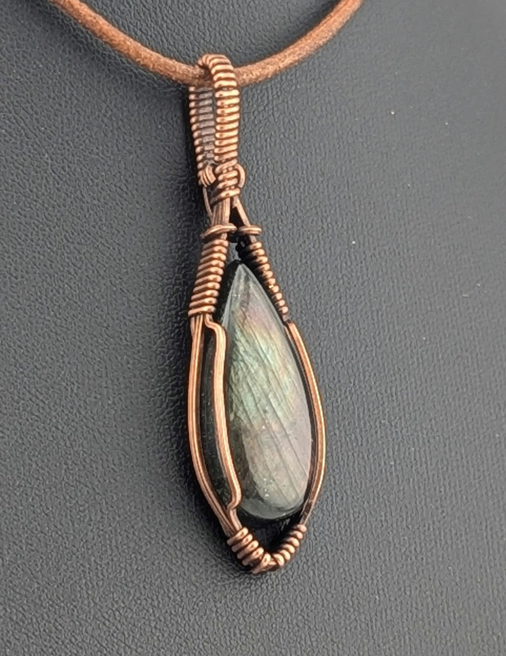 Labradorite pendant with purple and green flash, set in antiqued copper.