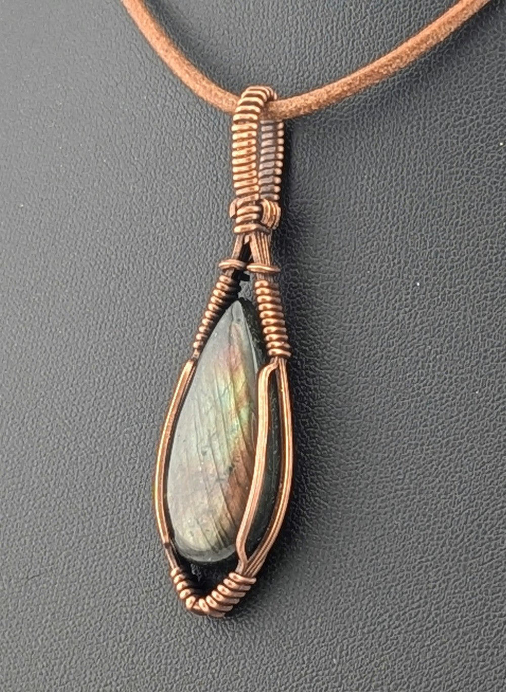 Labradorite pendant with purple and green flash, set in antiqued copper.