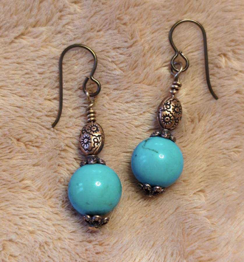 Turquoise earrings with a decorative antiqued copper bead.