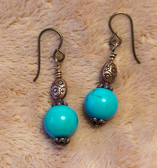 Turquoise earrings with a decorative antiqued copper bead.