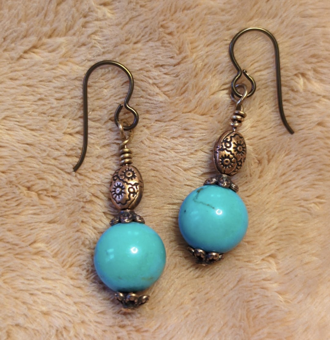 Turquoise earrings with a decorative antiqued copper bead.